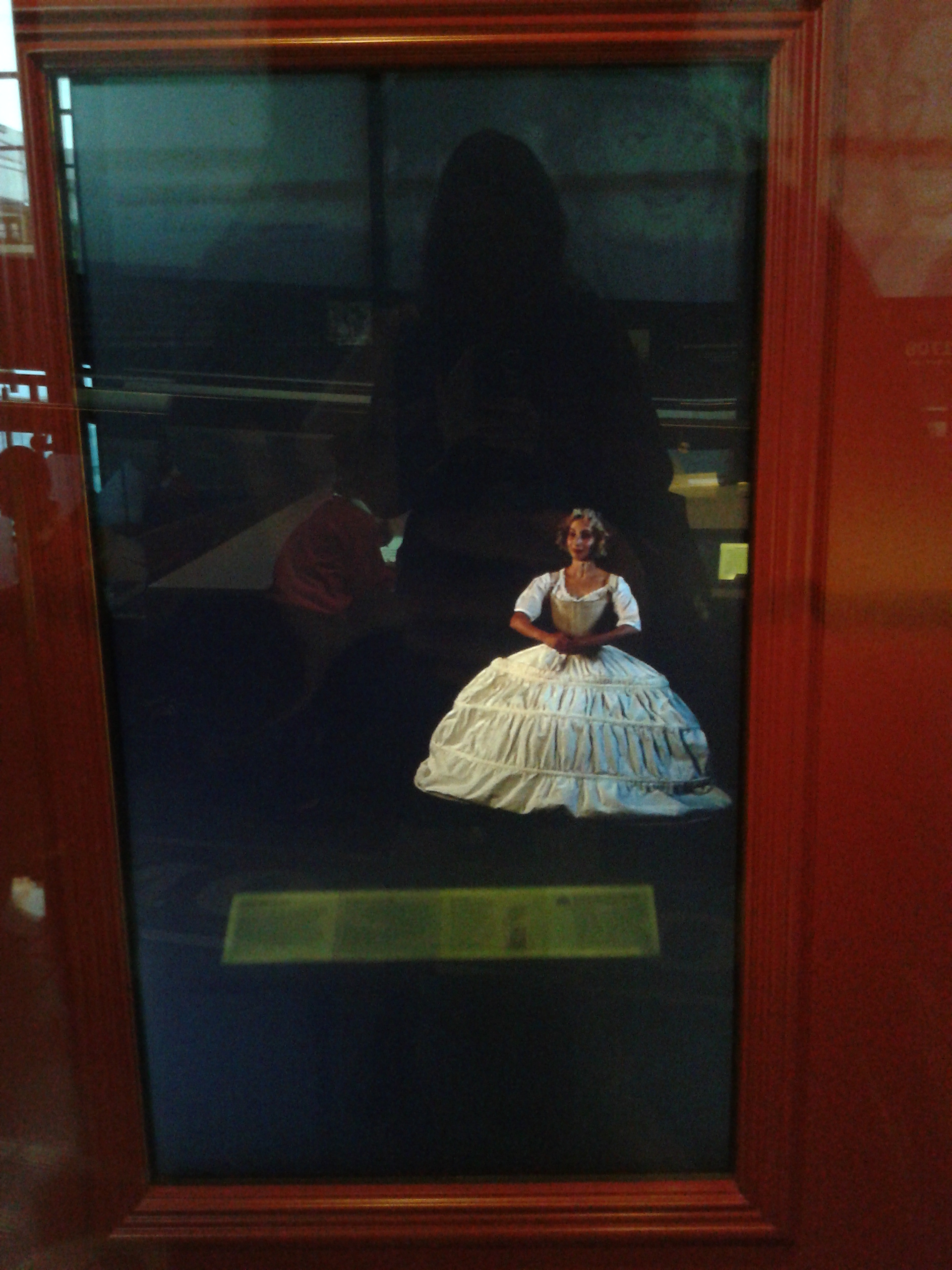 Actor demonstrating how to curtsey in an 18th century court dress.